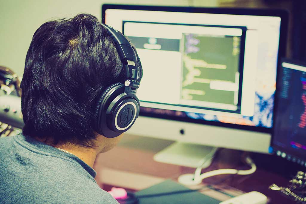 man at computer with headphones